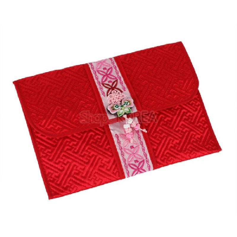 붉은색 누비 원단에 기하학 무늬를 넣고, 중앙에 분홍색 자수띠와 매듭 장식을 더한 전통 스타일 지갑