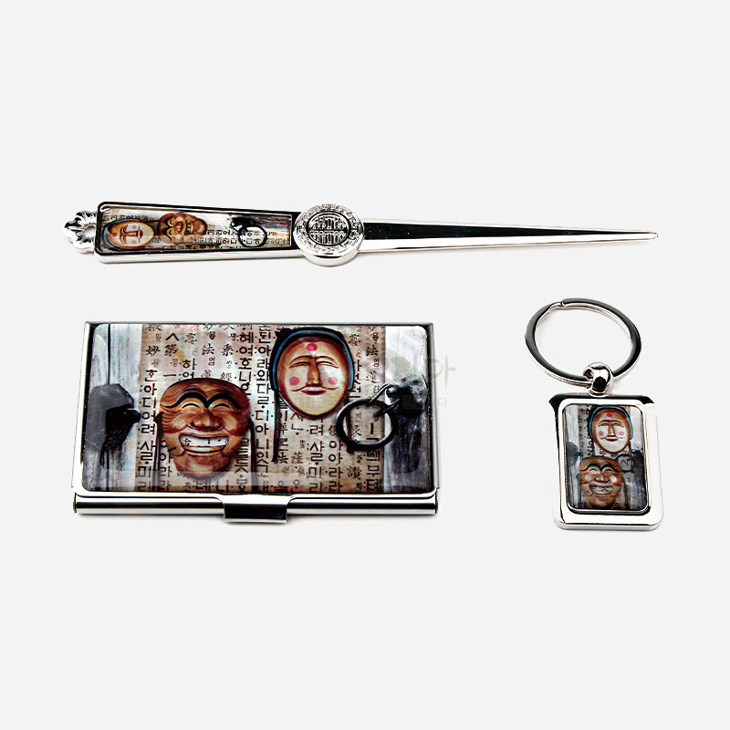 금속 재질 위에 하회탈 3종과 한글 서체를 인쇄한 명함집·편지칼·키링 세트, 은색 광택과 갈색·붉은색 대비가 돋보이는 구성.