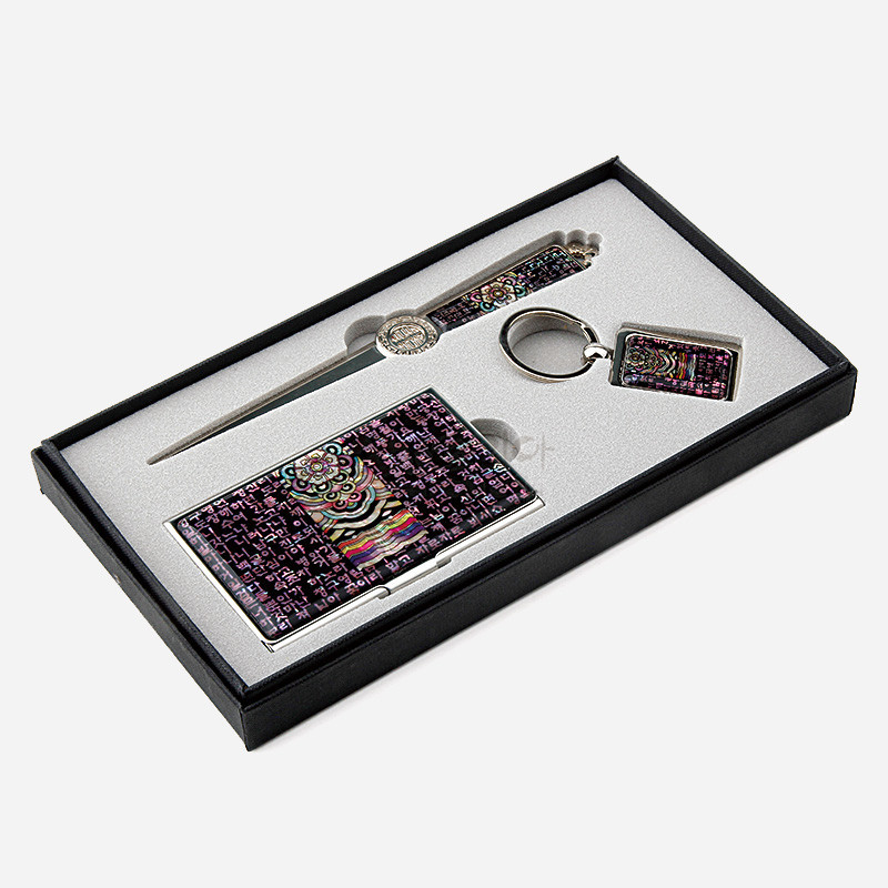 금속 테두리에 자개 장식을 더하고, 보라색 바탕 위 시조 글귀와 단청 문양, 오방색 포인트가 어우러진 명함집·책갈피·키링 세트. 금속 테두리에 자개 장식을 더하고, 보라색 바탕 위 시조 글귀와 단청 문양, 오방색 포인트가 어우러진 명함집·책갈피·키링 세트.