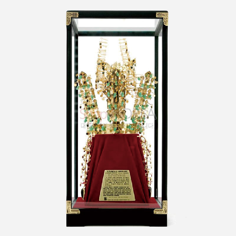 금속과 옥 장식으로 표현한 천마총 금관 모형, 유리 진열 케이스와 적색 천 받침대 구성.