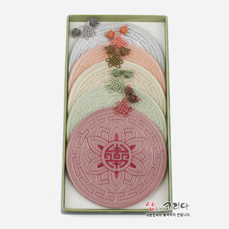 은은한 파스텔 색상의 원형 누비 컵받침 세트, 연꽃과 수복문 자수 문양과 전통 매듭 장식이 조화를 이룬 패브릭 공예품.