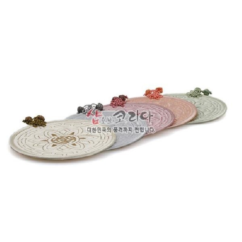 은은한 파스텔 톤 천으로 만든 원형 누비 컵받침 세트, 연꽃 문양과 수실 매듭 장식이 특징인 구성.