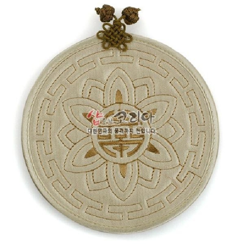 연베이지색 천 소재에 누비 기법으로 연꽃과 전통 길상문을 수놓은 원형 컵받침.