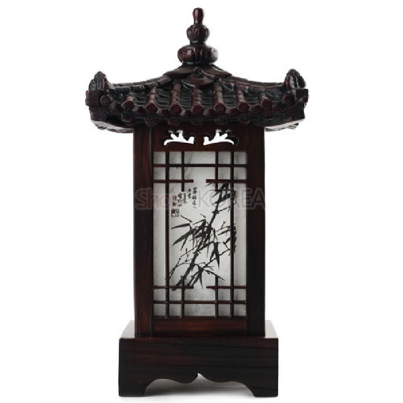 짙은 갈색 목재와 기와형 지붕 조각, 창살 구조와 한지에 그린 대나무 문양이 조화된 미니 좌등.