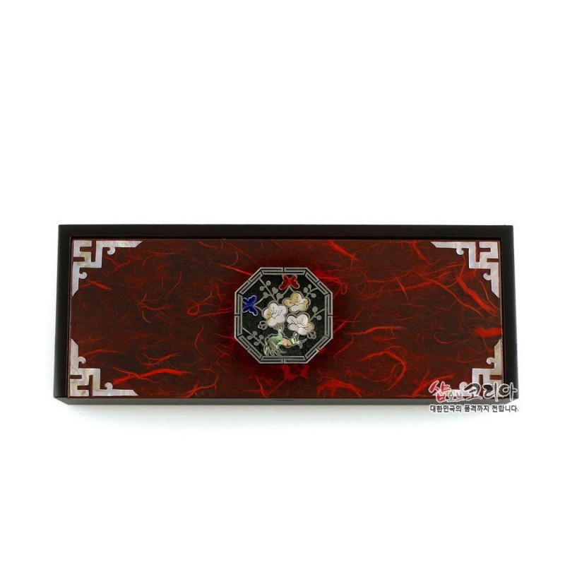 적색 한지 바탕에 흑색 테두리를 두르고 중앙 팔각 매화 자개 장식과 모서리 금속 기하문을 더한 자동함.