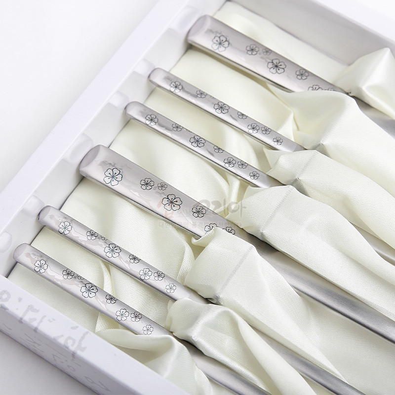 은은한 광택의 금속 소재에 섬세한 매화 문양이 음각된 실버 톤 전통 수저 세트.