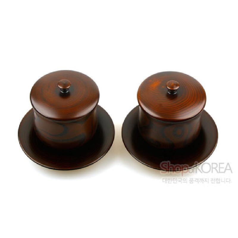 짙은 갈색 천연 옻칠 마감과 나뭇결 무늬가 돋보이는 뚜껑과 받침 구성의 찻잔 세트.