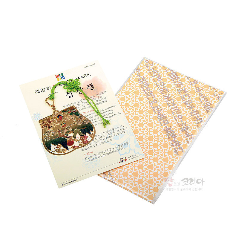 금도금 금속 소재에 십장생 부채 문양을 새긴 책갈피와 연두색 전통 매듭 장식 구성이 특징인 상품.