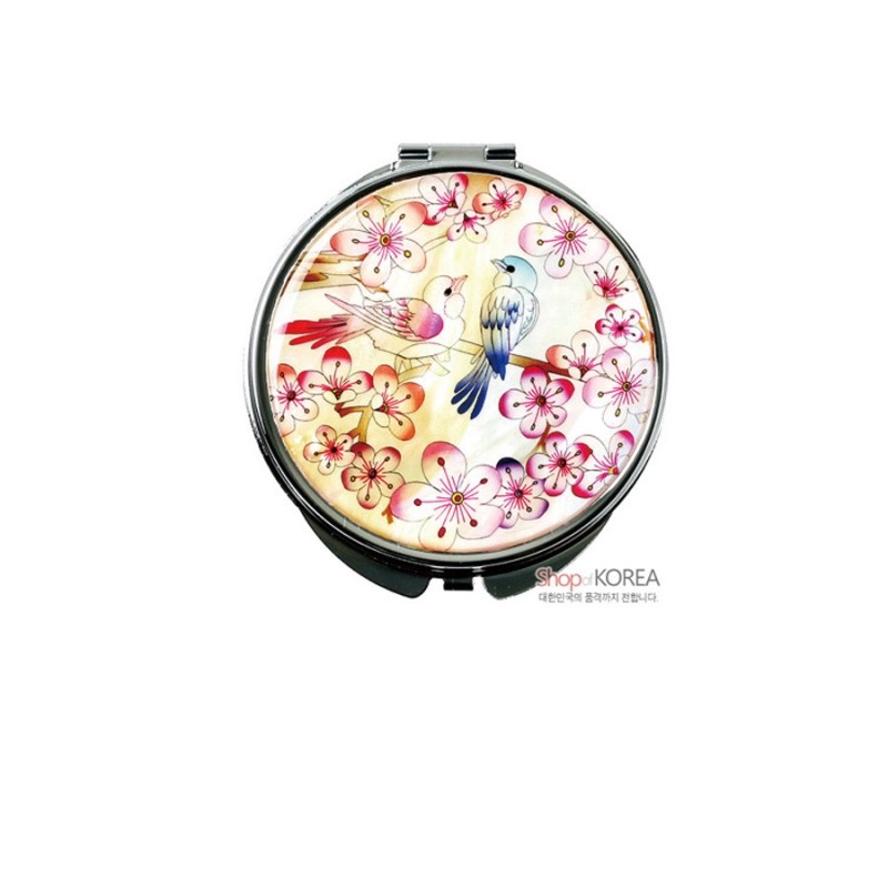 자개 상감 기법으로 연분홍 매화와 한쌍의 새를 표현한 원형 금속 손거울.