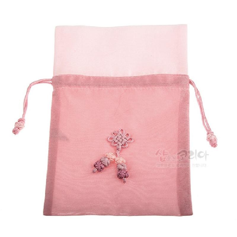 옅은 연분홍 색의 반투명 천으로 만든 복주머니로, 중앙에 전통 매듭 기법으로 장식된 삼색 술 문양이 수놓여 있다.