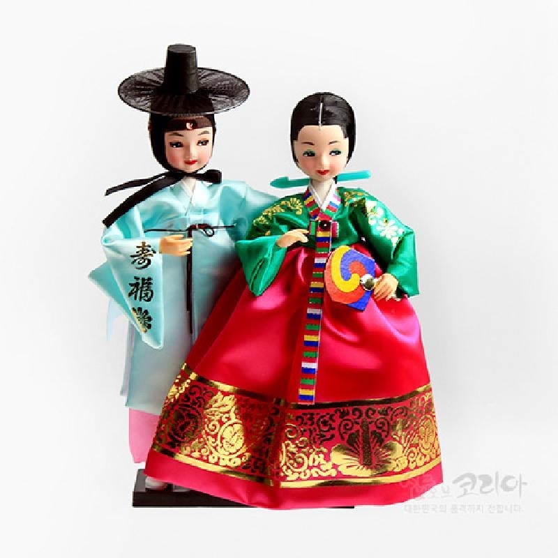 비단 소재의 한복을 입은 선비와 여인 인형, 금박 문양 치마와 오방색 장식, 전통 갓과 화려한 색채 대비가 특징인 세트.