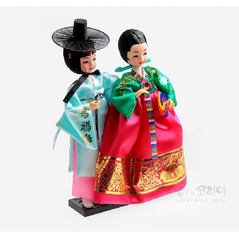 비단 소재 한복을 입은 선비와 여인 한복인형, 금박 단청 문양 치마와 오방색 띠 장식이 돋보이는 전통 복식 장식.