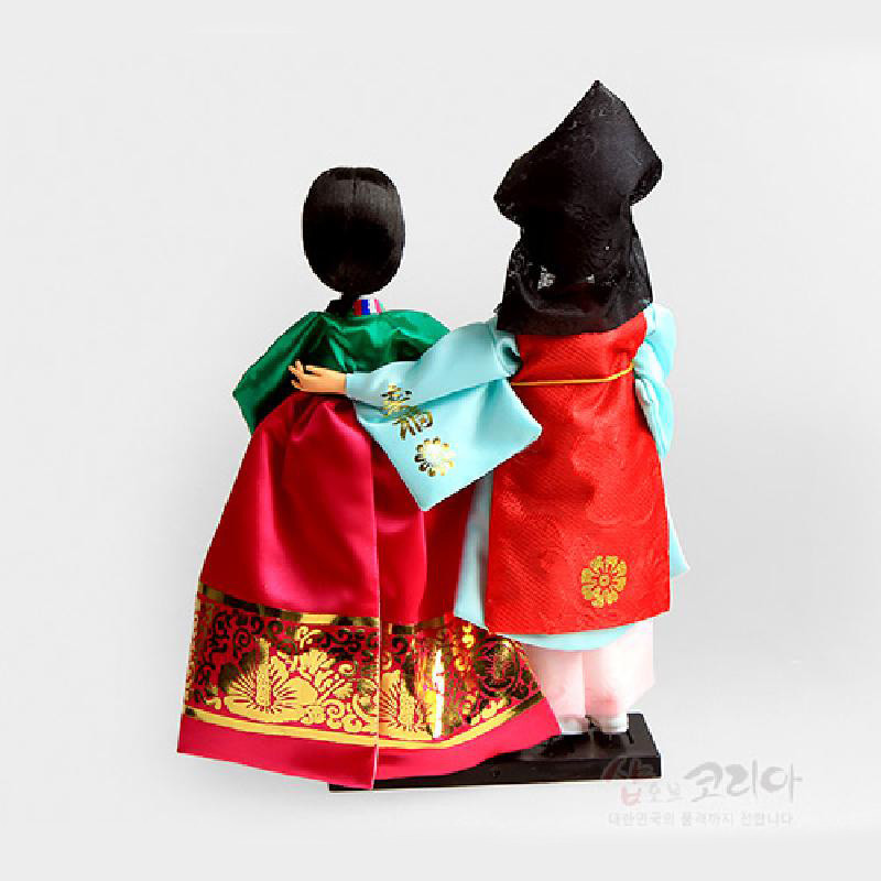 비단 한복을 입은 도령과 아씨 인형, 금박 꽃문양과 붉은·청록 대비 색상이 돋보이는 전통 복식 장식.