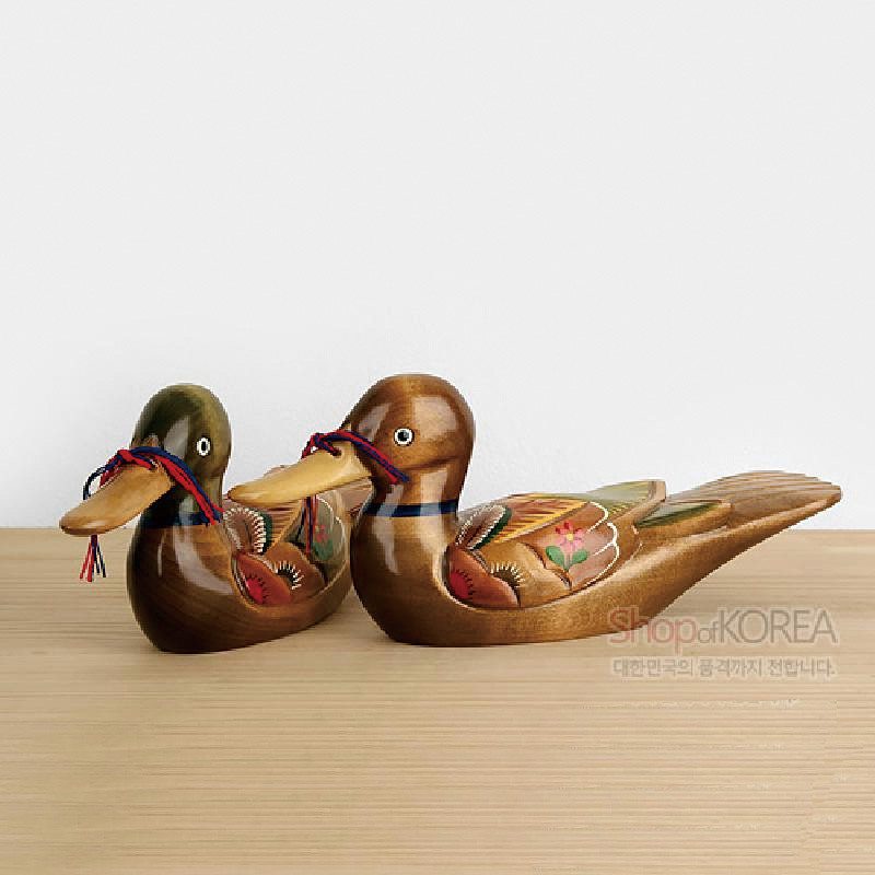 나무 재질에 옻칠 마감된 원앙 한 쌍, 날개에 꽃과 잎을 채색한 민화풍 문양과 오색 매듭 장식이 특징인 목각 장식.