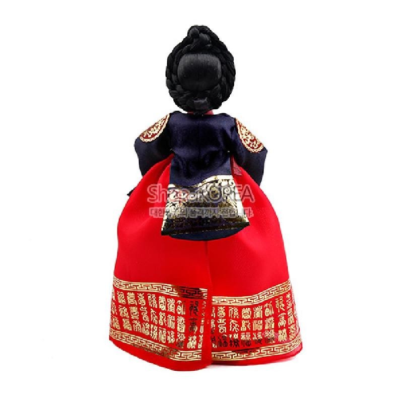 붉은 치마와 남색 저고리에 금박 궁중 문양을 더한 비단 한복 인형, 정교한 기녀머리 땋기 장식이 특징인 공예품.