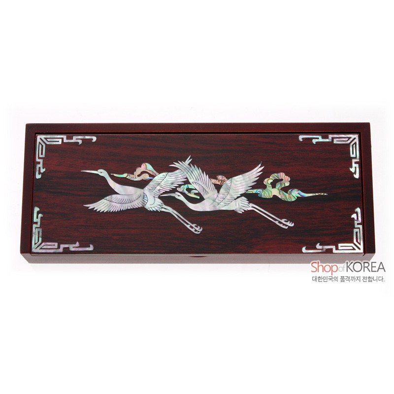 진한 목재 바탕에 자개 상감으로 운학 문양을 새긴 직사각형 자동함, 모서리 기하학 장식 특징.