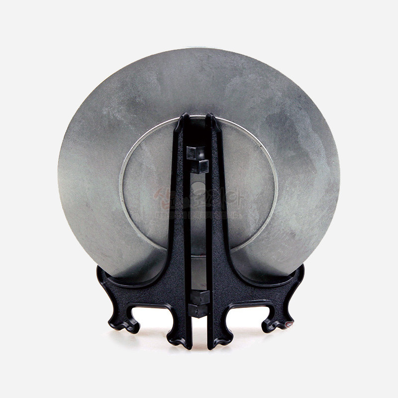 회색빛 주석 재질 원형 판과 흑색 플라스틱 받침대로 구성된 단색 장식 접시.