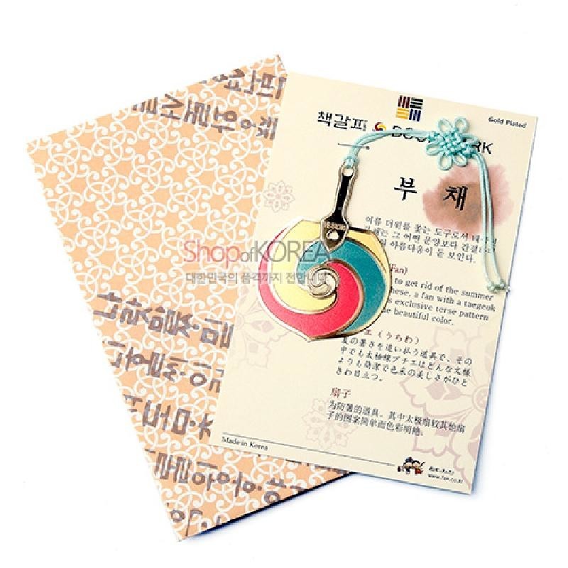 금장 금속 재질에 빨강·파랑·노랑 태극무늬 부채 장식과 하늘색 전통 매듭끈이 특징인 책갈피.