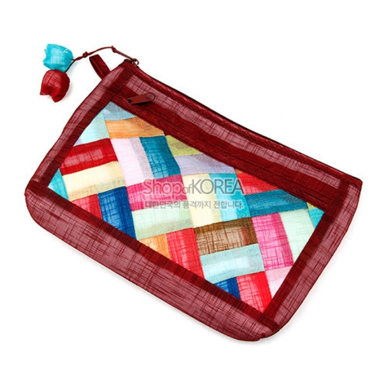 적갈색 모시 테두리에 다채로운 색상의 조각보 기법이 더해진 지퍼형 파우치, 실크 매듭 장식이 포인트인 디자인. 적갈색 모시 테두리에 다채로운 색상의 조각보 기법이 더해진 지퍼형 파우치, 실크 매듭 장식이 포인트인 디자인.