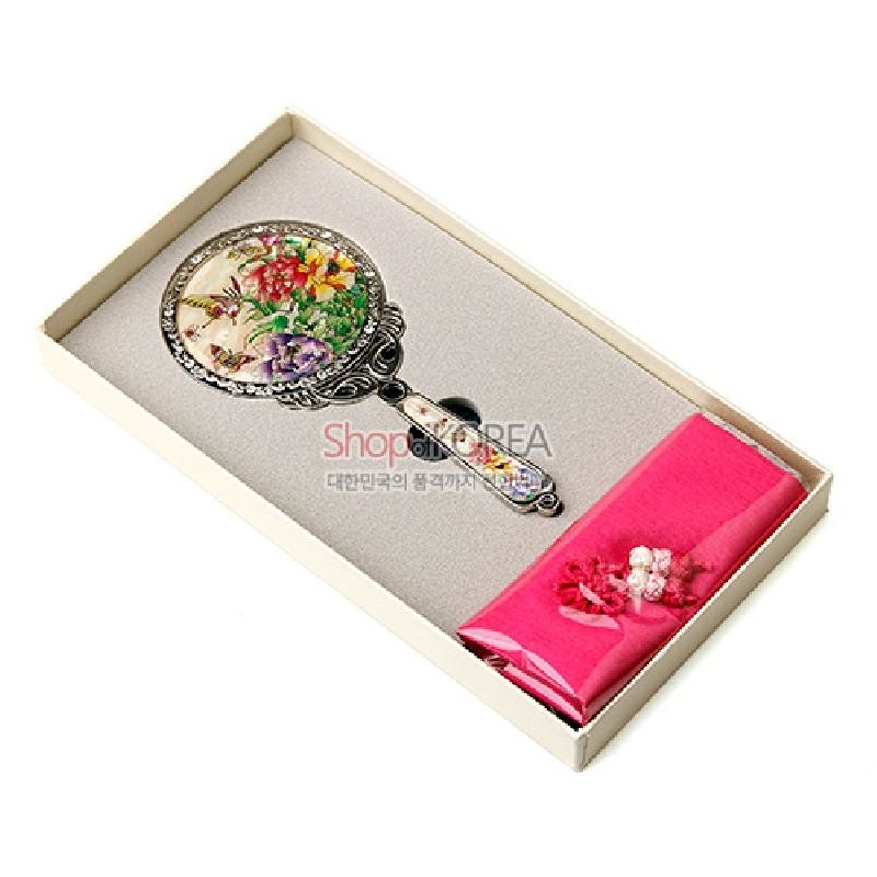 자개 상감 기법으로 목단꽃과 나비 문양을 장식한 금속 손거울과 분홍 비단 주머니 세트.