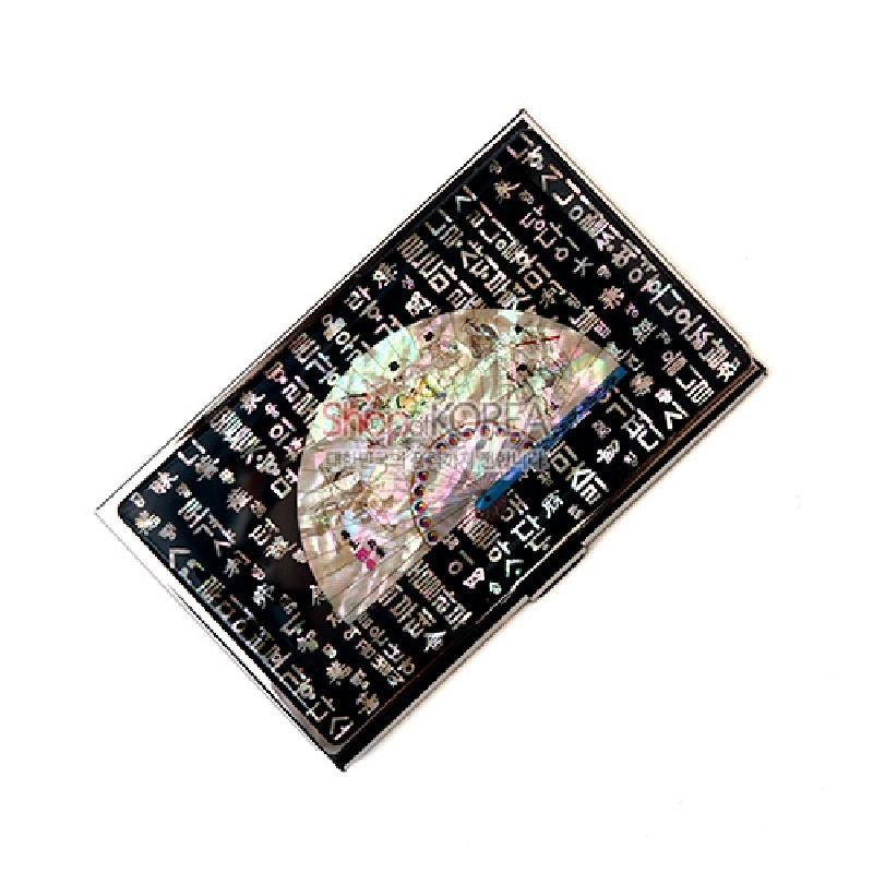 검은 바탕 위 자개 상감 부채 문양과 흰색 훈민정음 글자 패턴이 조화를 이룬 금속 명함집. 검은 바탕 위 자개 상감 부채 문양과 흰색 훈민정음 글자 패턴이 조화를 이룬 금속 명함집.