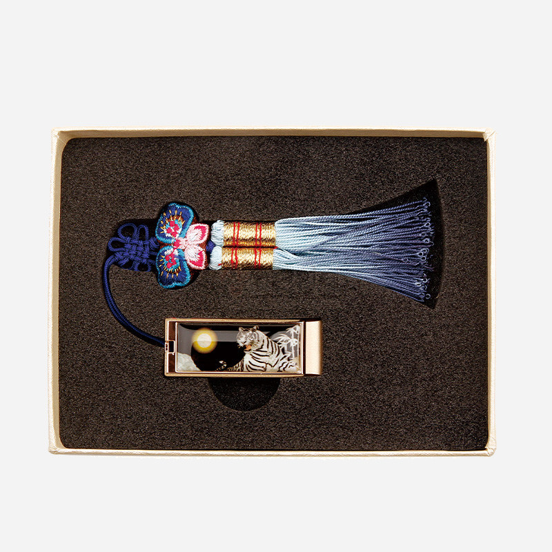 자개 상감으로 백호와 달 문양을 넣은 금속 USB와 청색·하늘색 그라데이션 술, 화려한 나비 매듭 장식의 구성.