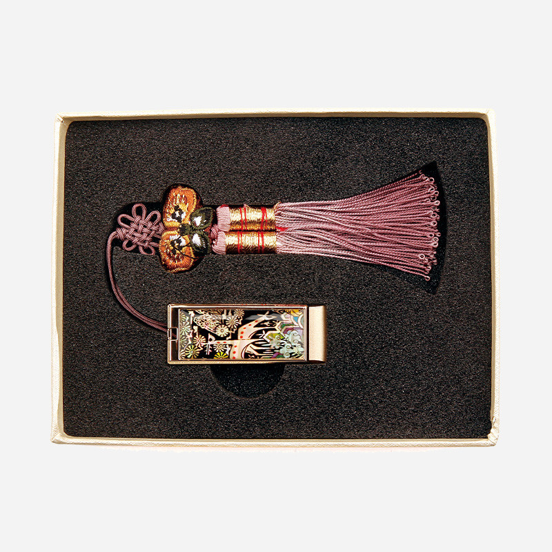 자개 상감으로 십장생 문양을 넣은 메탈 USB와 자색 비단 실로 엮은 나비 매듭 술 장식.