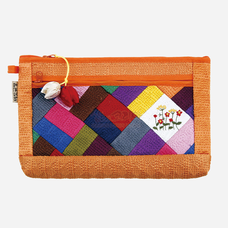 주황색 누비 천을 기본으로 다채로운 조각보 패치워크와 꽃 자수 장식, 조개 모양 노리개 고리가 더해진 파우치.