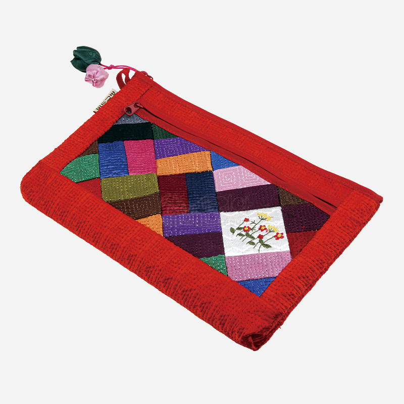 적색 누비 천을 바탕으로 다채로운 색 조각보 패치를 잇고 꽃자수와 매듭장식이 더해진 파우치.