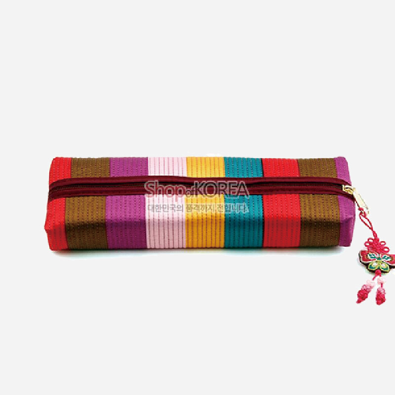 색동 누비 기법의 다색 원단으로 제작된 직사각형 필통, 나비 매듭 장식이 달린 지퍼 여밈 구조.