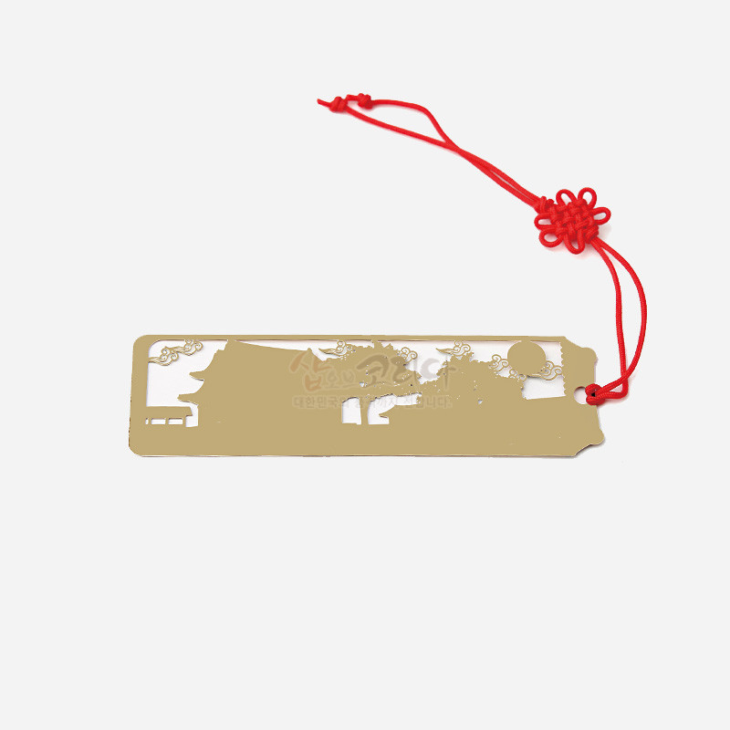 금속 재질에 창덕궁 인정전 실루엣을 레이저 컷팅한 금장 책갈피와 붉은 전통 매듭 장식 끈. 금속 재질에 창덕궁 인정전 실루엣을 레이저 컷팅한 금장 책갈피와 붉은 전통 매듭 장식 끈.