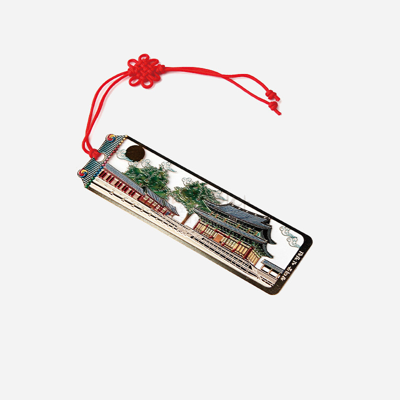 금속 재질 위에 창덕궁 인정전을 세밀하게 채색한 직사각 책갈피와 붉은 전통 매듭 끈 장식. 금속 재질 위에 창덕궁 인정전을 세밀하게 채색한 직사각 책갈피와 붉은 전통 매듭 끈 장식.