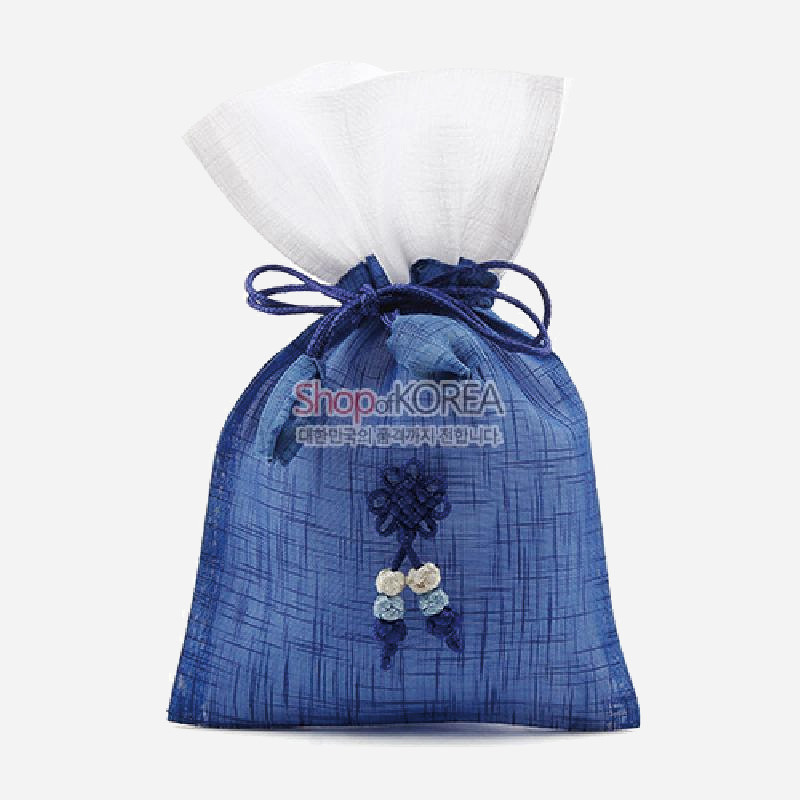 청색 모시 원단에 세로결 무늬가 더해지고, 앞면에 전통 매듭과 작은 꽃 장식이 달린 복주머니형 주머니.