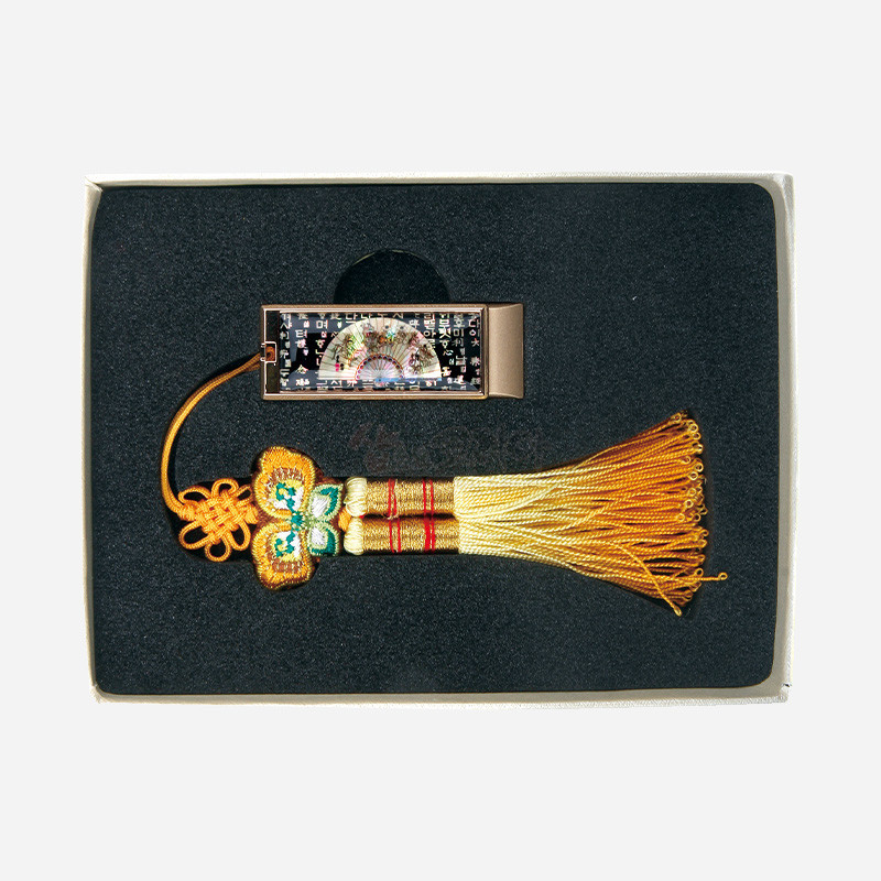 자개로 표현된 부채와 훈민정음 문자 문양이 있는 금속 USB 본체와 황금색 비단 매듭 술 장식의 세트.