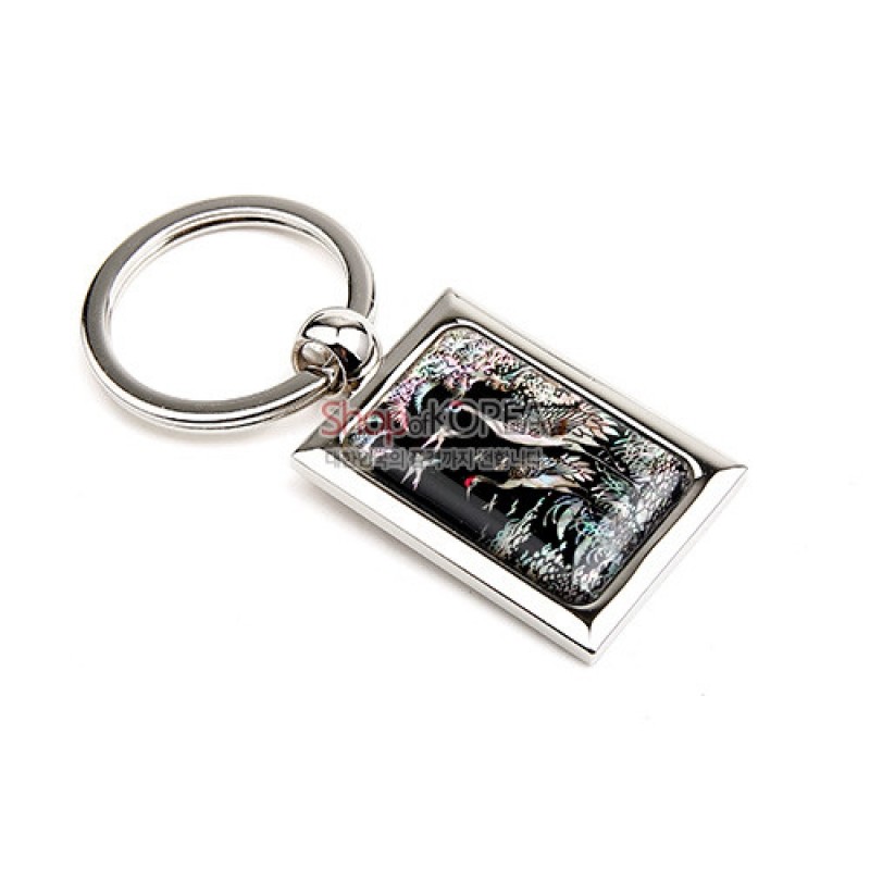 금속 테두리에 흑색 바탕 자개 상감으로 송학과 소나무 문양을 담은 직사각형 키홀더.