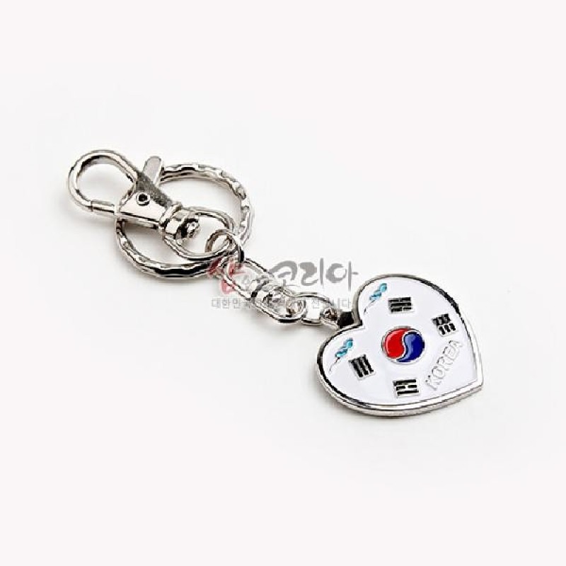 하트형 메탈 장식에 흰색 에나멜 배경과 태극기 문양, 은색 광택 금속 체인과 고리로 구성된 열쇠고리.
