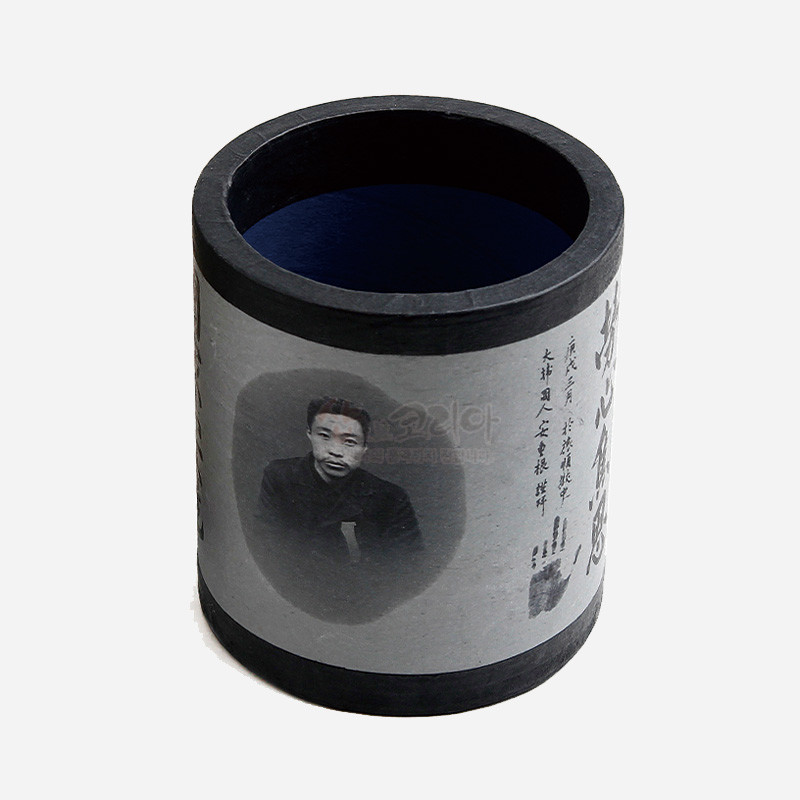 흑백 톤 한지 감싸기 기법의 원통형 펜꽂이, 인물 사진과 한글 서예 문양이 인쇄된 디자인.