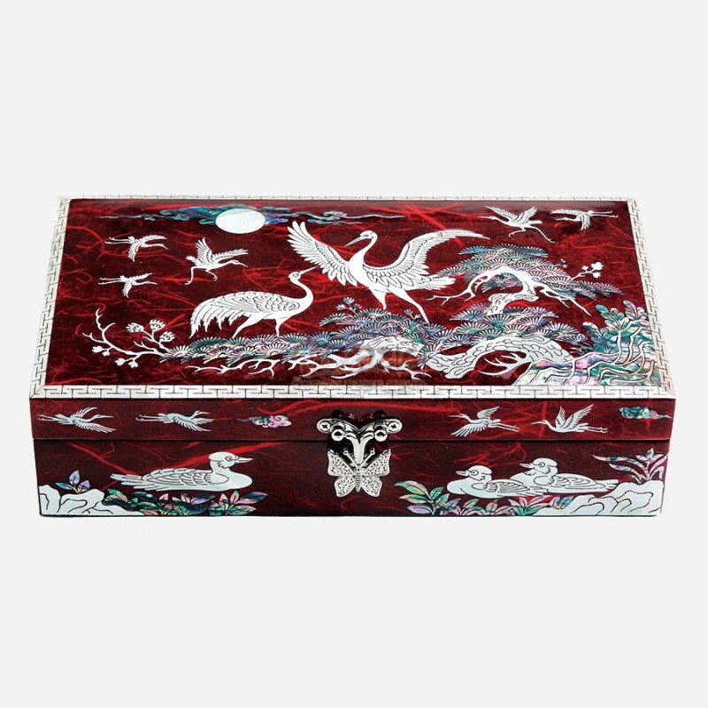 자개 상감 기법으로 학과 소나무, 구름 문양을 섬세하게 표현한 붉은색 옻칠 보석함.