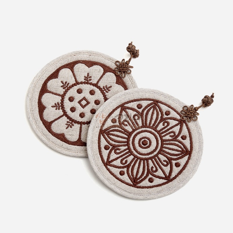 베이지색 천 위에 갈색 자수로 고구려·백제 수막새 꽃문양을 표현한 원형 컵받침 2P세트.