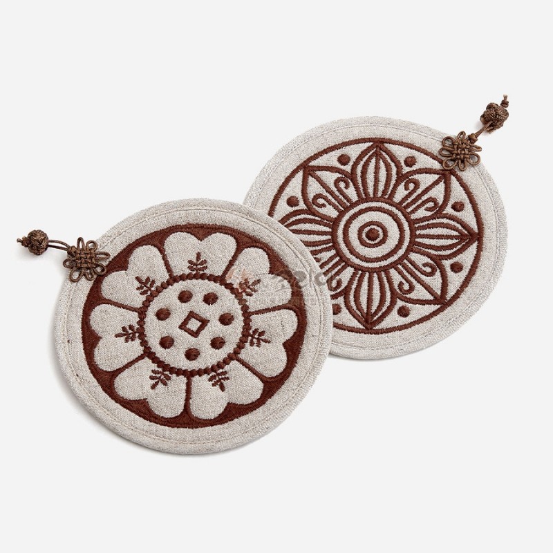 베이지 천 소재에 갈색 자수 기법으로 고구려·백제 수막새 연꽃 문양을 표현한 원형 컵받침 2P 세트.