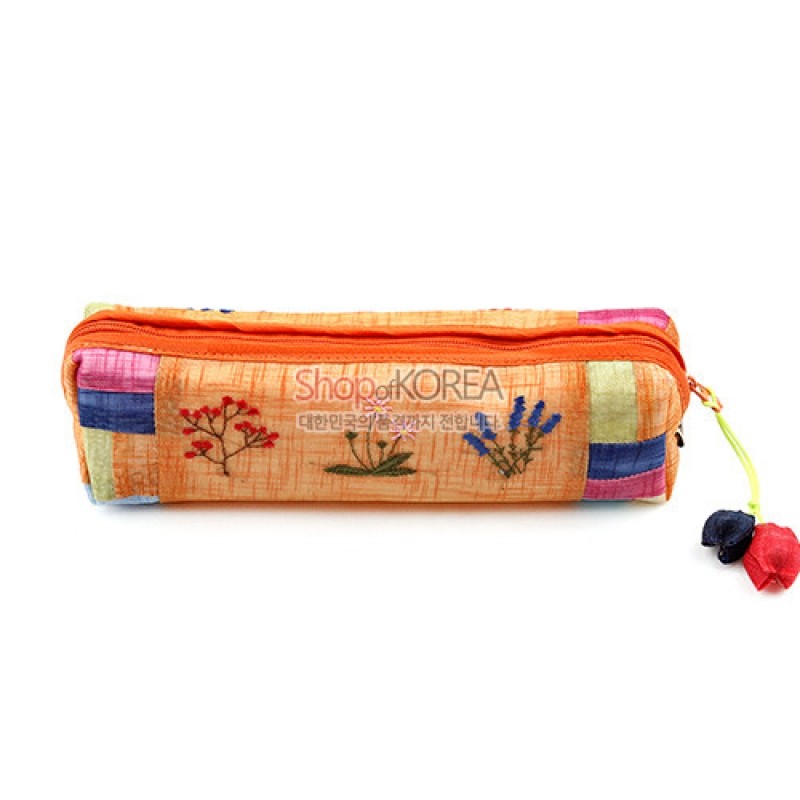 노란 모시 천에 꽃자수와 색동 배색, 조개 모양 매듭 장식이 더해진 필통.