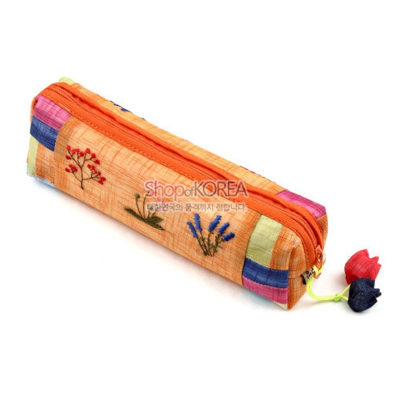 황색 모시로 제작된 필통에 꽃자수 장식과 다채로운 색상의 조각천 배색, 꽃 모양 매듭 장식이 더해진 필통. 황색 모시로 제작된 필통에 꽃자수 장식과 다채로운 색상의 조각천 배색, 꽃 모양 매듭 장식이 더해진 필통.