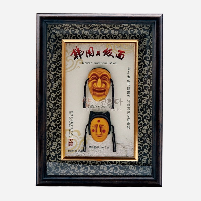 목재 액자에 금색 테두리와 당초무늬 장식을 두른 배경 위, 노랑빛 하회탈 두 개가 입체 부조로 배치된 장식 액자.
