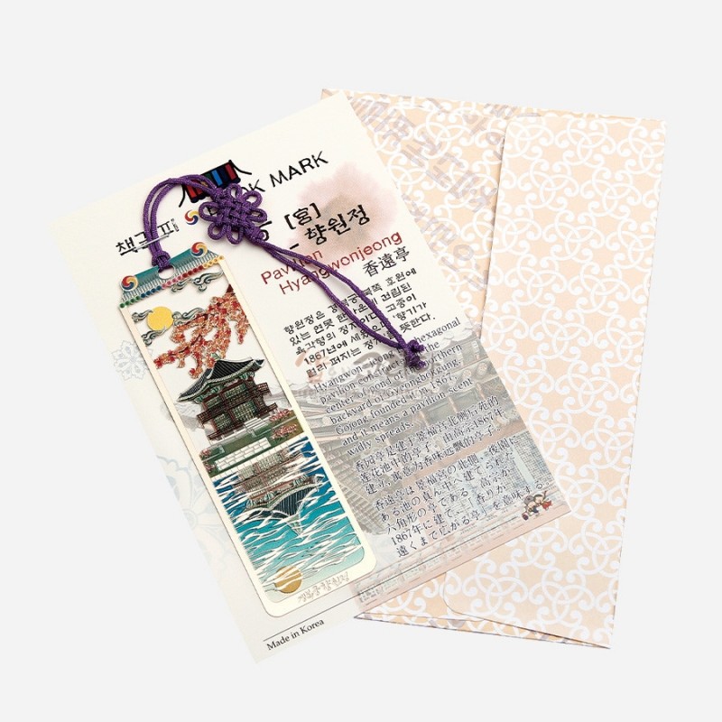 금속 재질에 향원정 건축과 물결, 구름, 해 문양을 섬세한 채색으로 표현하고 보라색 전통 매듭 끈이 장식된 책갈피.