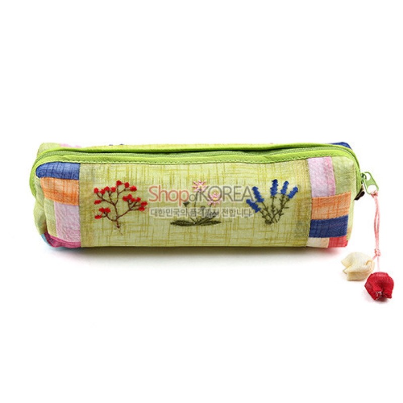 연두색 모시 소재에 붉은 꽃과 풀 수를 놓은 자수 장식, 배색 조각천과 매듭 노리개 장식이 어우러진 필통.