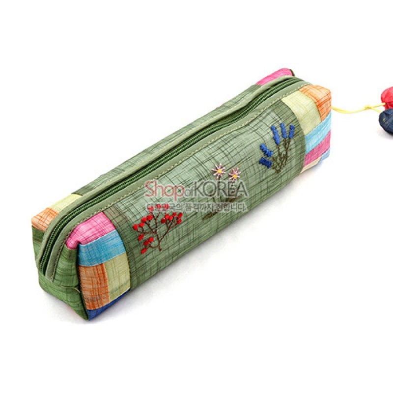 모시 재질의 녹색 바탕에 붉은 꽃과 푸른 꽃 자수 장식, 양끝 한복 조각보 배색이 특징인 지퍼형 필통. 모시 재질의 녹색 바탕에 붉은 꽃과 푸른 꽃 자수 장식, 양끝 한복 조각보 배색이 특징인 지퍼형 필통.