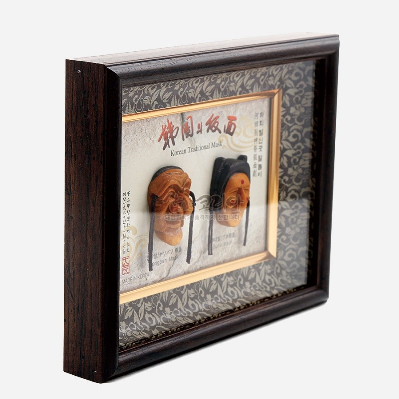 나무 재질의 액자 안에 황갈색 하회탈 미니어처를 입체 배치하고, 가장자리에 당초무늬 장식지를 둘러 전통 문양을 강조한 장식 액자. 나무 재질의 액자 안에 황갈색 하회탈 미니어처를 입체 배치하고, 가장자리에 당초무늬 장식지를 둘러 전통 문양을 강조한 장식 액자.