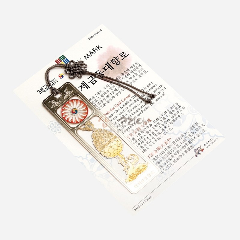 금속 재질에 금도금 처리된 백제 금동대향로 문양과 태극 문양 장식, 매듭줄 장식이 더해진 전통 책갈피.