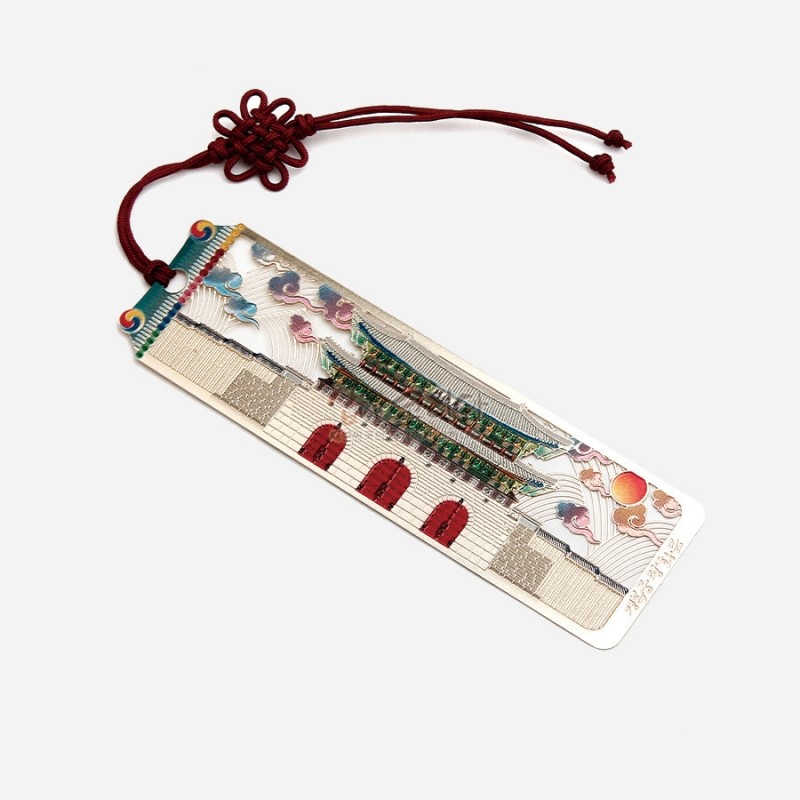 금속 재질에 광화문 전경과 오방색 구름, 해 문양을 섬세한 채색으로 표현한 책갈피, 붉은 전통 매듭 끈 장식.