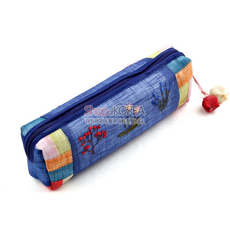 청색 모시 원단 위에 꽃자수 장식과 오방색 조각 천 배색, 실 매듭 장식 지퍼가 특징인 필통. 청색 모시 원단 위에 꽃자수 장식과 오방색 조각 천 배색, 실 매듭 장식 지퍼가 특징인 필통.